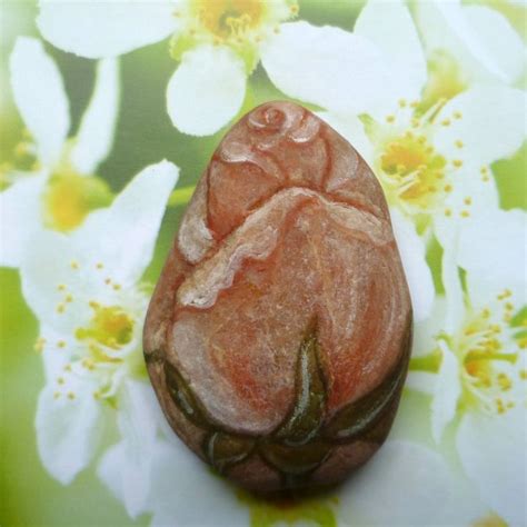 A Close Up Of A Rock With Flowers In The Background