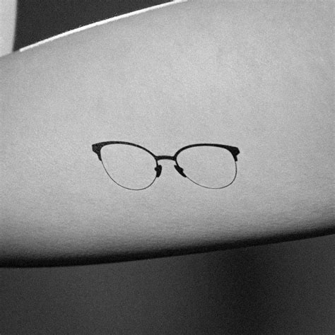 A Minimal Cat-Eye Glasses Tattoo Design in Silhouette Style.