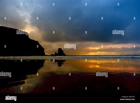 Storm clouds over waves on beach Stock Photo - Alamy