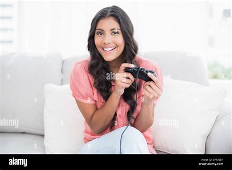 Happy Cute Brunette Sitting On Couch Holding Controller Stock Photo Alamy