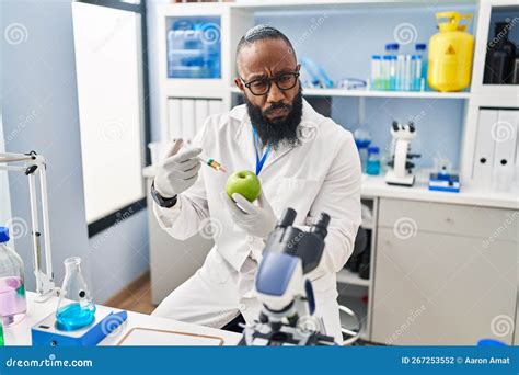 African American Man Working At Scientist Laboratory With Apple