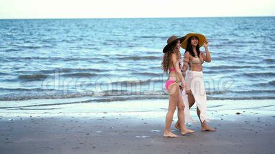 Mujeres Felices En Bikini Que Hablan Y Que Caminan En La Playa Almacen