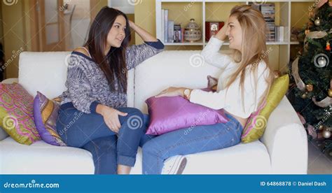 Two Adorable Girls Sitting On Couch And Talking Stock Photo Image Of