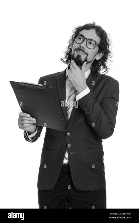 Handsome Caucasian Businessman Reading Clipboard While Thinking Stock