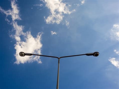 Poste ligero eléctrico de calle en el cielo vivo azul en luz del día