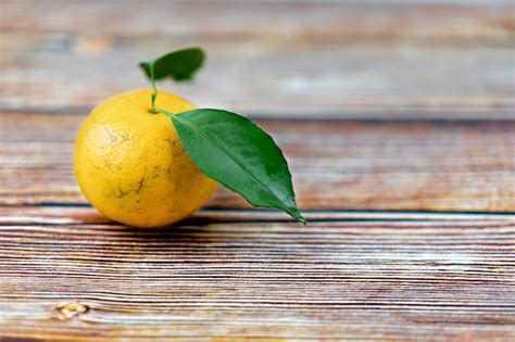 Premium Photo Orange Fruits With Leaf On Wooden Table