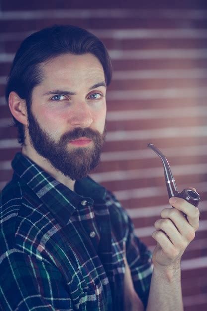 Premium Photo Portrait Of Confident Hipster Smoking Pipe