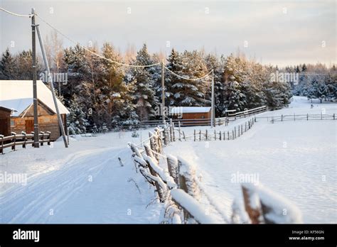 Winter with lot of snow in Russian village, rural street in sunset ...