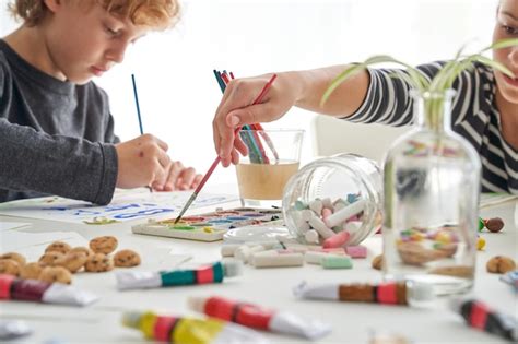 Niños pintando con pinturas en la mesa Foto Premium