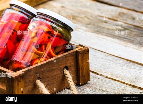 Wooden Crate With Glass Jars With Pickled Red Bell Peppers Preserved