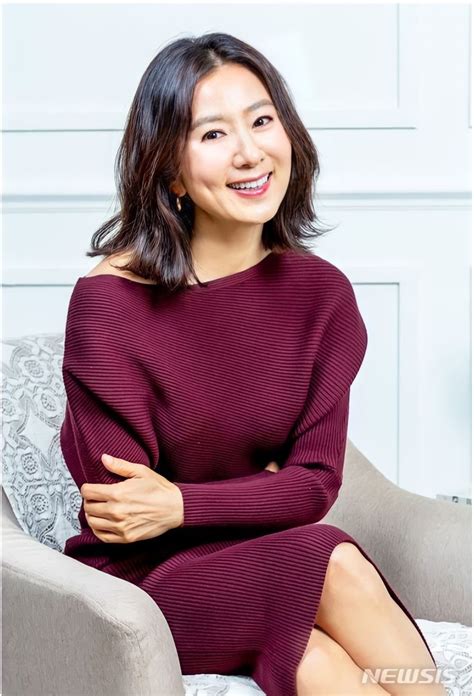 A Woman Sitting In A Chair With Her Arms Crossed