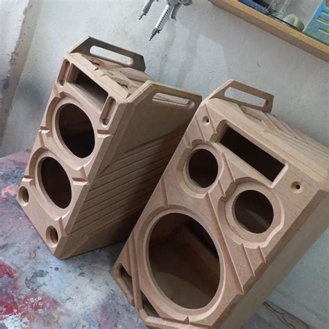 Two Wooden Speakers Sitting On Top Of A Table