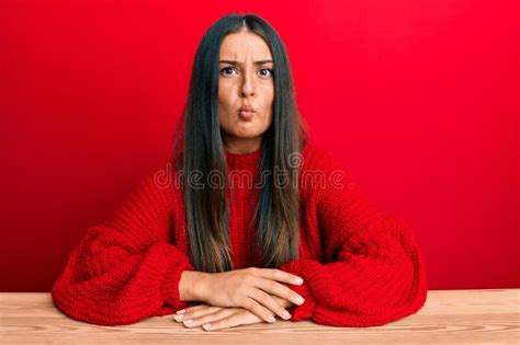 Beautiful Hispanic Woman Wearing Casual Clothes Sitting On The Table