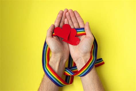 Male Hands With Rainbow Gay Pride Lgbt Ribbon Wristband Holding Paper