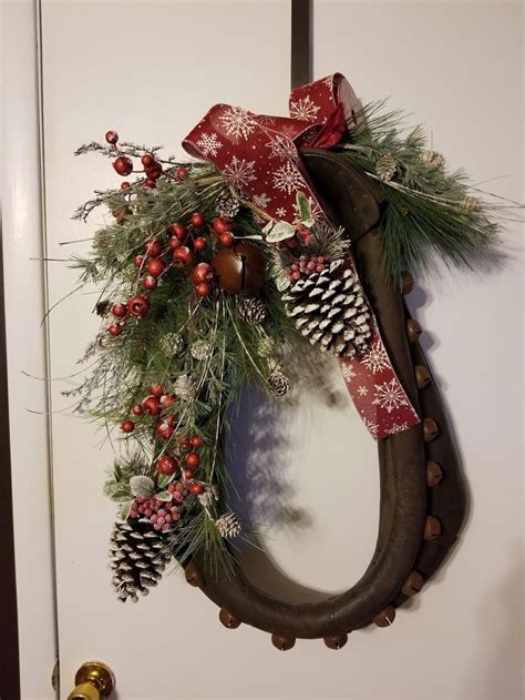 A Christmas Wreath Hanging On The Front Door With Pine Cones Berries