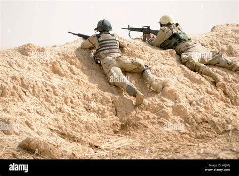 Iraqi Soldiers Establish Security From Behind An Earthen Berm During A