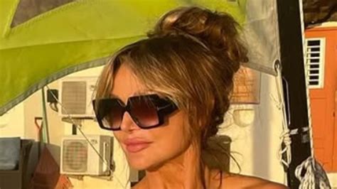 Lizzie Cundy Protects Her Modesty With A Straw Hat While Posing In The Nude As She Enjoys A