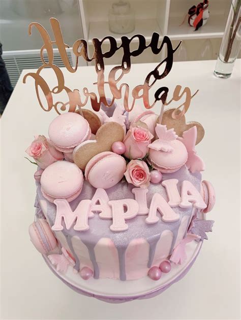 A Birthday Cake With Pink Frosting And Decorations On Top That Says