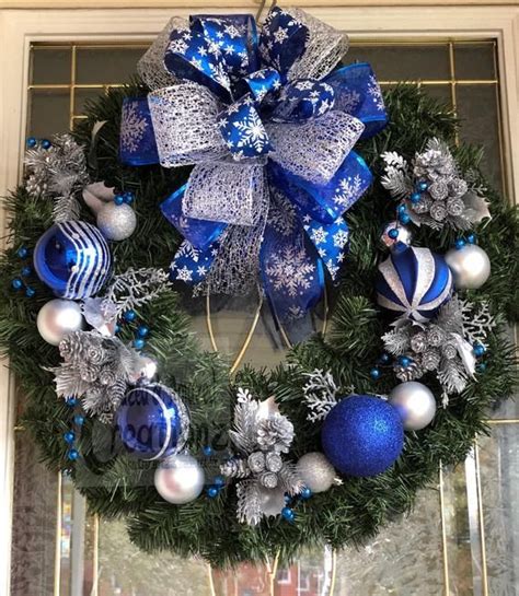 Blue And Silver Ornament Wreath On An Evergreen With A Large Bow