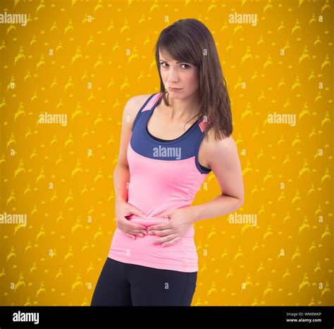 Festive Fit Brunette Pinching Her Stomach Against Yellow Background