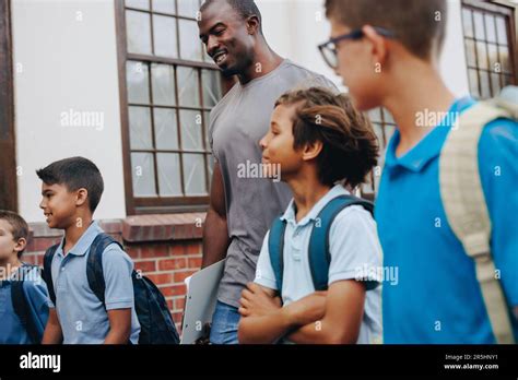 Maestro De Escuela Masculino Caminando Fuera De Clase Con Sus