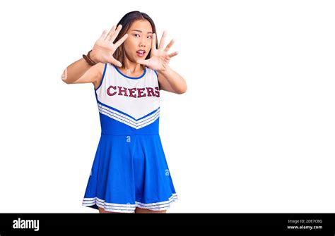 Young Beautiful Chinese Girl Wearing Cheerleader Uniform Afraid And