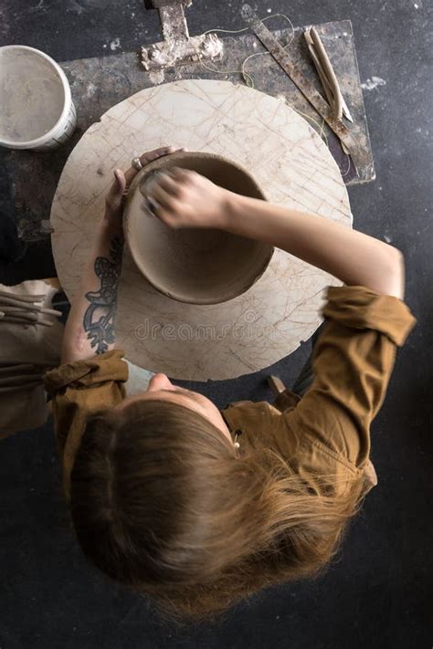 Female Potter Making Vase In Workshop Standing Near Window Stock Photo