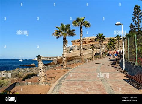 Tourists Stroll Along The Promenade In La Caleta Costa Adeje Tenerife