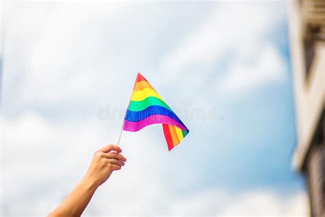 Mano Femenina Con Una Pulsera De Orgullo Gay Con Banderas De Arco Iris Contra El Cielo Lgbt