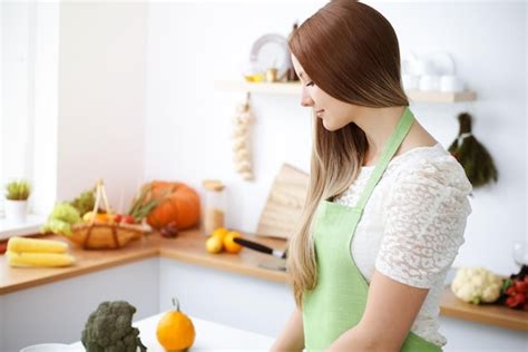 Premium Photo | Beautiful woman dressed in apron cooking meal in sunny ...