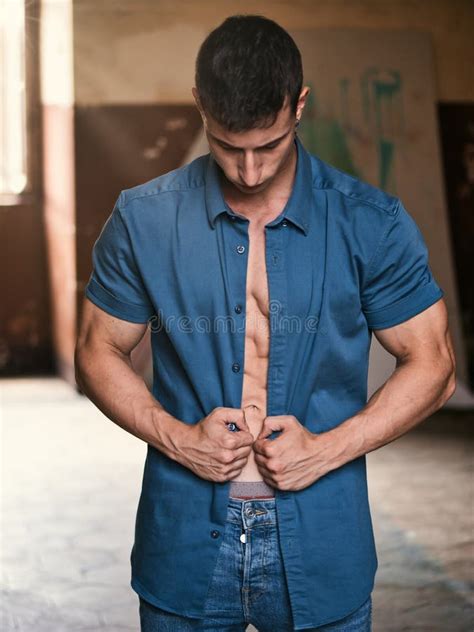 Attractive Young Man Opening Shirt To Show Muscular Body Stock Photo