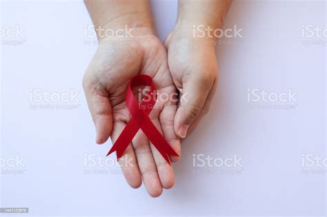 복사 공간이 있는 Hiv 질병 기호를 보여주는 빨간 리본을 들고 있는 손의 클로즈업 보기 인식 개념입니다 의료 개념입니다 세계