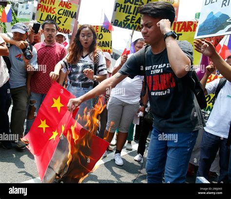 Protesters burn a mock Chinese flag during a rally at the Chinese ...