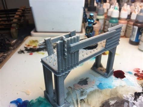 A Toy Figurine Stands On Top Of A Bridge In The Process Of Painting