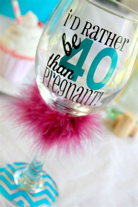 There Is A Wine Glass With The Number 40 On It And A Pink Fluffy Ball