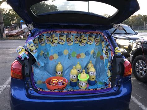 the back end of a blue car filled with stuffed animals and minions from the movie despicables