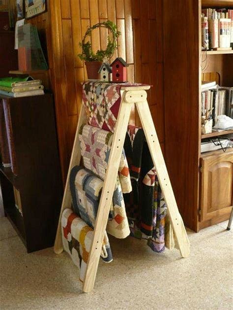 A Wooden Ladder Holding Quilts And Blankets In A Room With Bookshelf