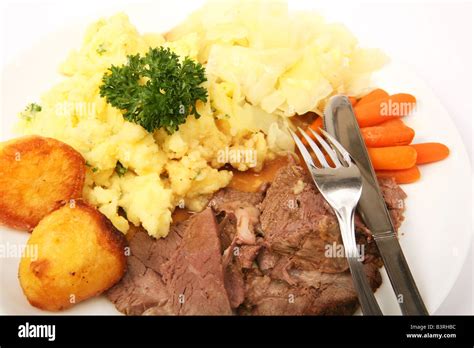 A roast lamb dinner with roast potatoes carrots mashed parsley potatoes and boiled cabbage Stock ...