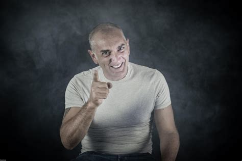 Premium Photo Portrait Of Smiling Man Pointing Against Wall At Home