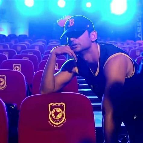 A Man Is Sitting In The Middle Of An Auditorium With His Hands On His Chin