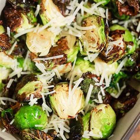 Brussel Sprouts With Shredded Parmesan Cheese In A White Dish