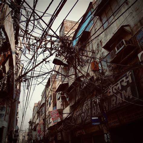 an alleyway with lots of electrical wires and signs on the building ...