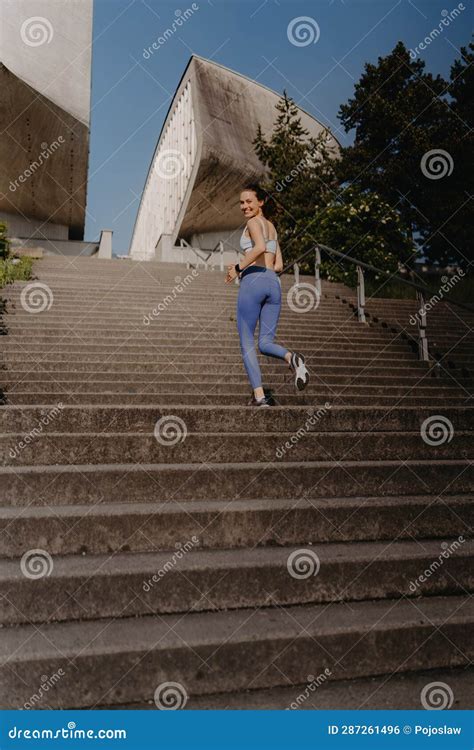 Portrait Of Sporty Woman Running On The Concrete Stairs In City Park