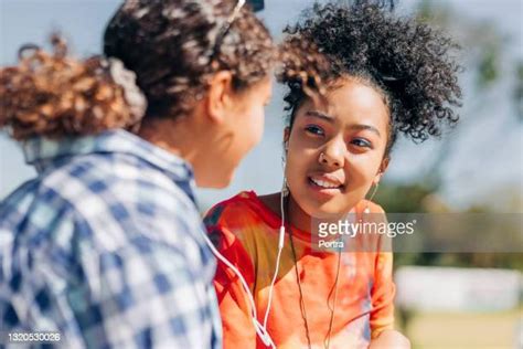 Two Preteen Girls Sharing Earphones Photos And Premium High Res