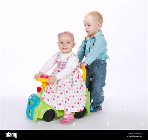 boy and girl ride on toy car Stock Photo - Alamy