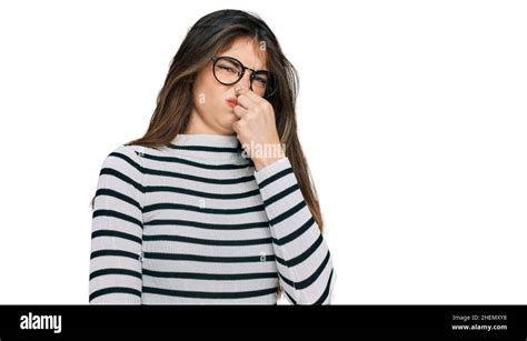 Young Beautiful Teen Girl Wearing Casual Clothes And Glasses Smelling