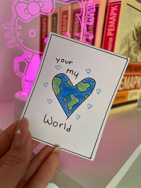 Someone Holding Up A Card That Says You Re My World With A Heart On It