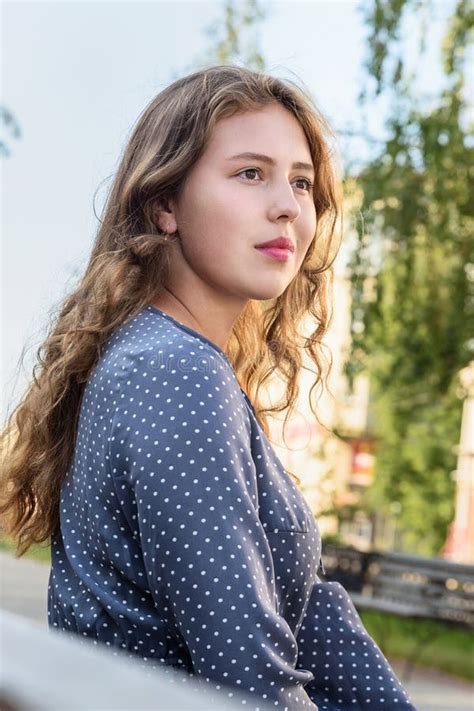 Une Fille Brunette Assise Sur Un Banc Dans La Ville Portrait D Une Fille En Robe Bleue Avec Des