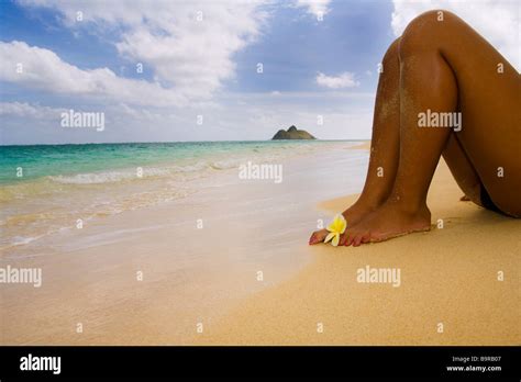 A Beautiful Polynesian Girl In A Black Bikini Lying On A Secluded Hawaii Beach With A Plumeria