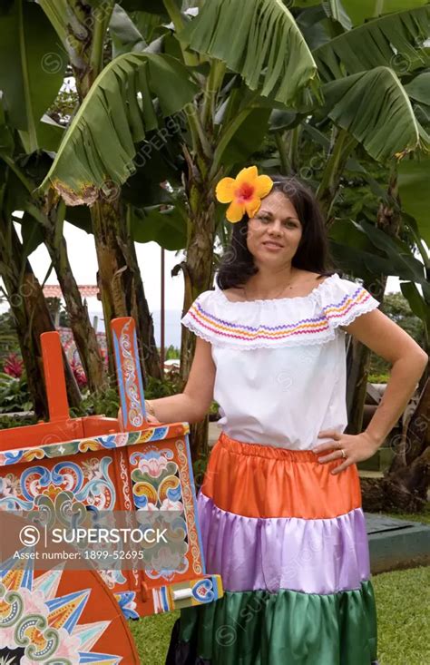 Costa Rican Woman In Traditional Dress Next To Traditional Carriage In